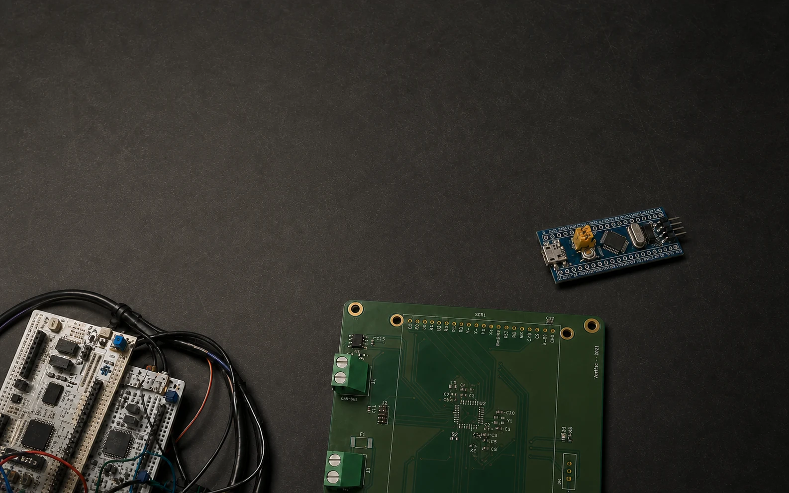 STM32 development boards, vehicle status PCB, and tire-pressure prototype arranged on a graphite worktable